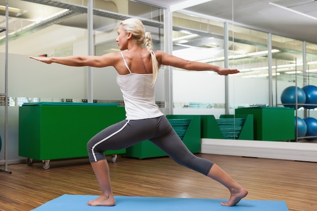 Fit woman doing stretching exercise in gym