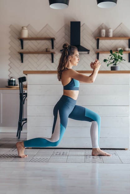 Photo fit woman exercising at home doing lunges exercise.