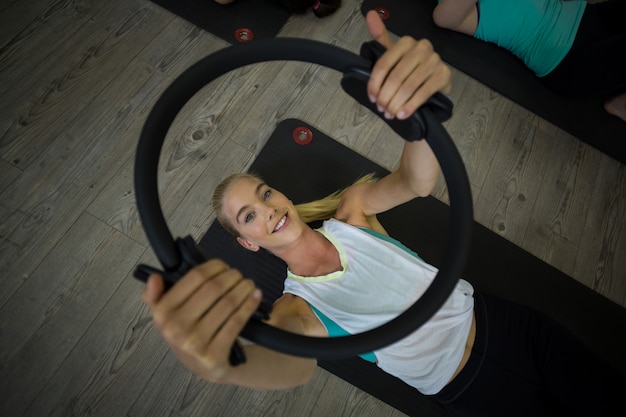 Fit woman exercising with pilates ring