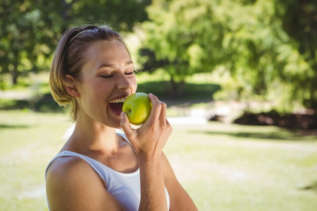 Fit woman holding green apple