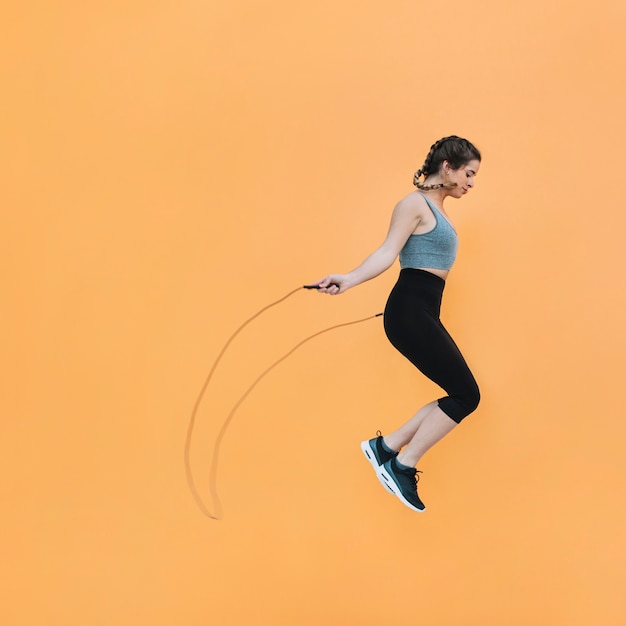 Fit woman jumping with rope