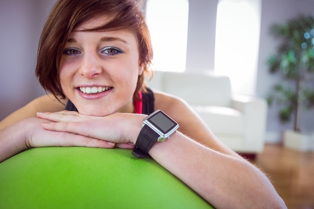 Fit woman leaning on exercise ball