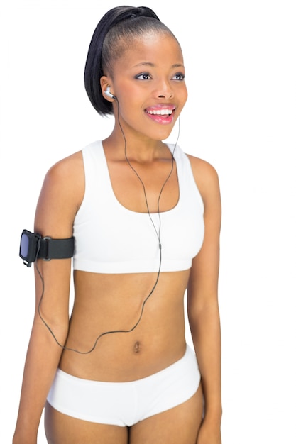 Fit woman in sportswear listening to music