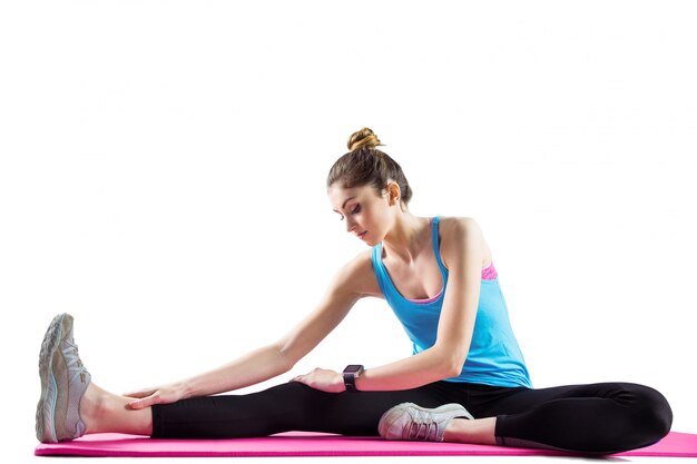 Fit woman stretching on exercise mat