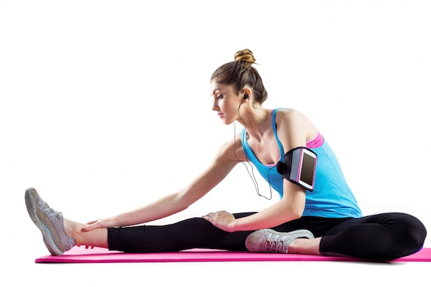 Fit woman stretching on exercise mat