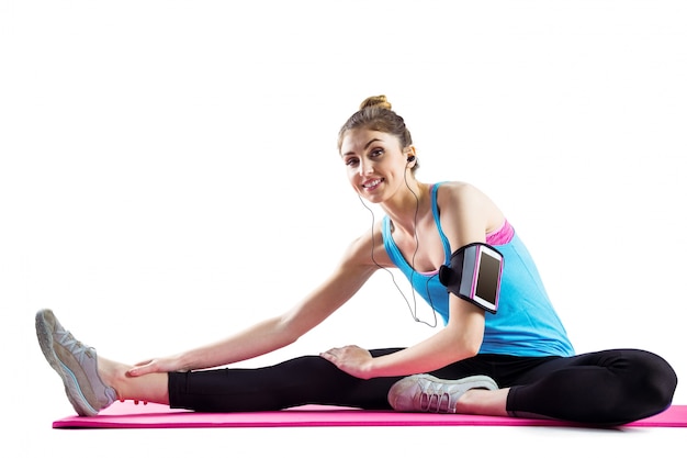 Fit woman stretching on exercise mat