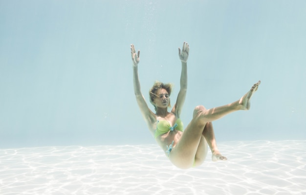 写真 プールの水の下で泳いでいる女性に合う