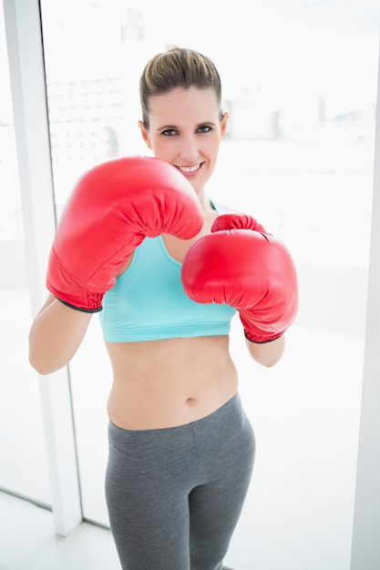 Fit woman wearing red boxing gloves