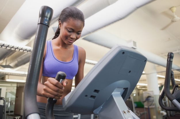 Fit woman working out on the cross trainer