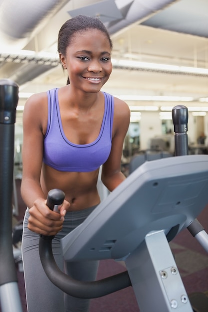 Fit woman working out on the cross trainer