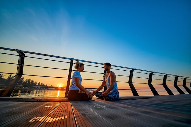 Fit giovane coppia che fa yoga lotus posa stile di vita sano persone attività sportiva all'aperto in famiglia vac...