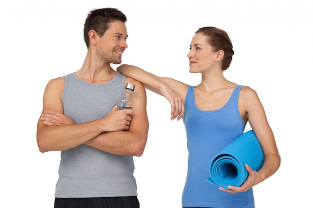 Fit young couple with exercise mat and water bottle