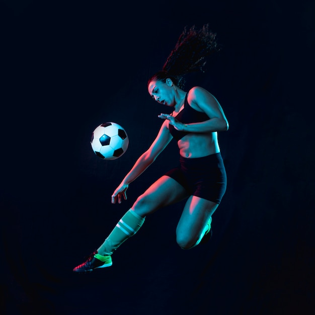 Photo fit young girl kicking soccer ball