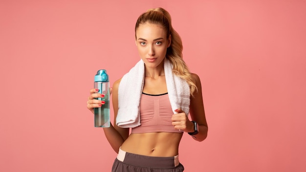 Fit Young Lady Standing Holding Water Bottle On Pink Background