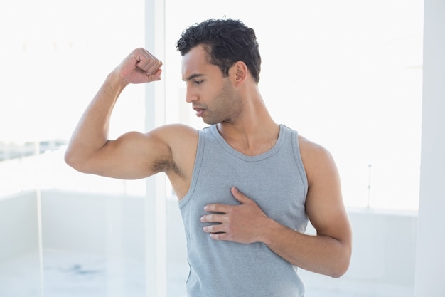 Fit young man flexing muscles in studio