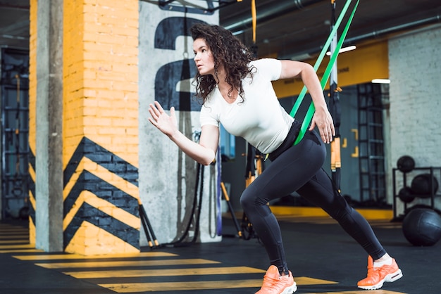 Fit young woman doing exercise in fitness club