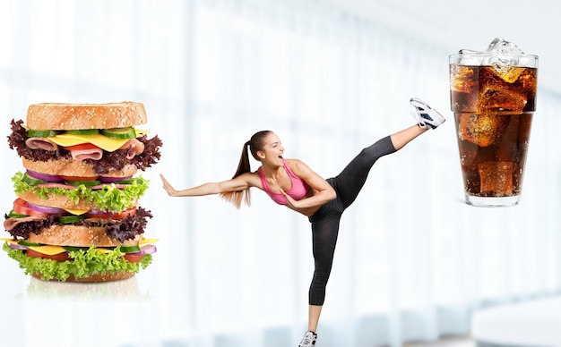 Fit young woman fighting off fast food