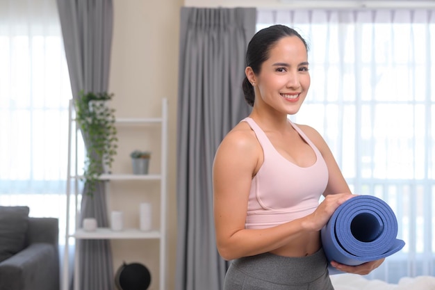 Fit young woman holding yoga mat sport and healthy lifestyle concept