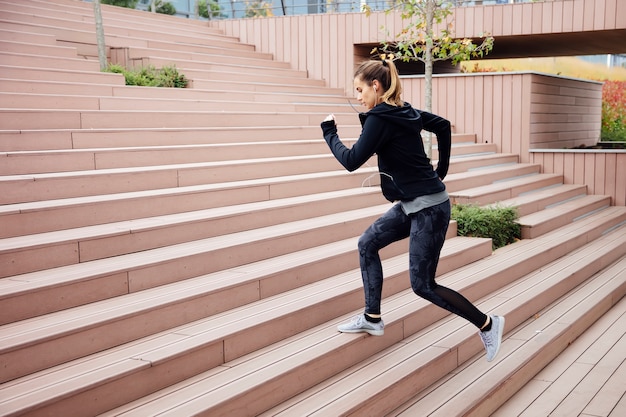 Fit young woman running on steps