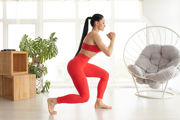 fit young woman wearing sportswear working out at home