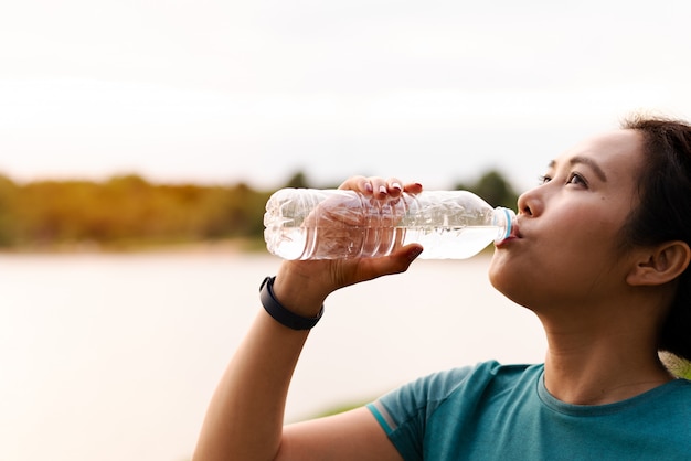 Acqua potabile della donna di forma fisica asia dopo avere corso