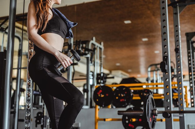 Fitness Asian Women exercising are lifting dumbbells with a whey protein placed next to the gym in the morningFitness muscular bodyFitness gym workout and healthy lifestyle concepts