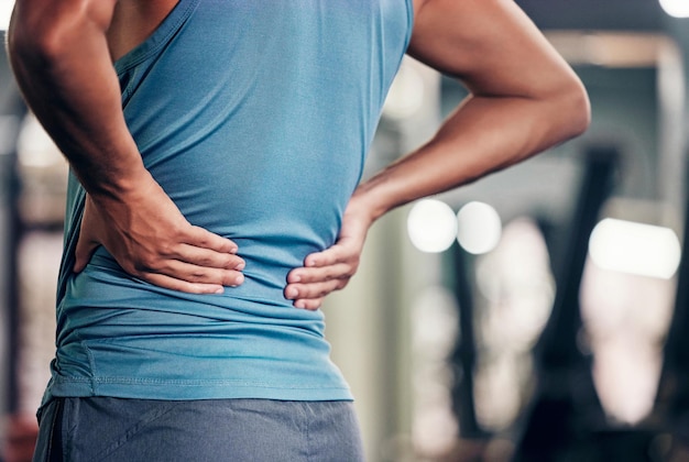 Foto mal di schiena fitness e mani dell'uomo per infortunio in palestra rischio sanitario e burnout con esercizio di corsa o allenamento zoom artrite scoliosi o problema muscolare della persona sportiva con dolore alla colonna vertebrale