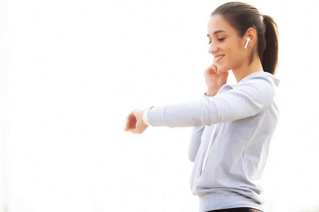 Fitness Beautiful woman drinking water and listen to music after running