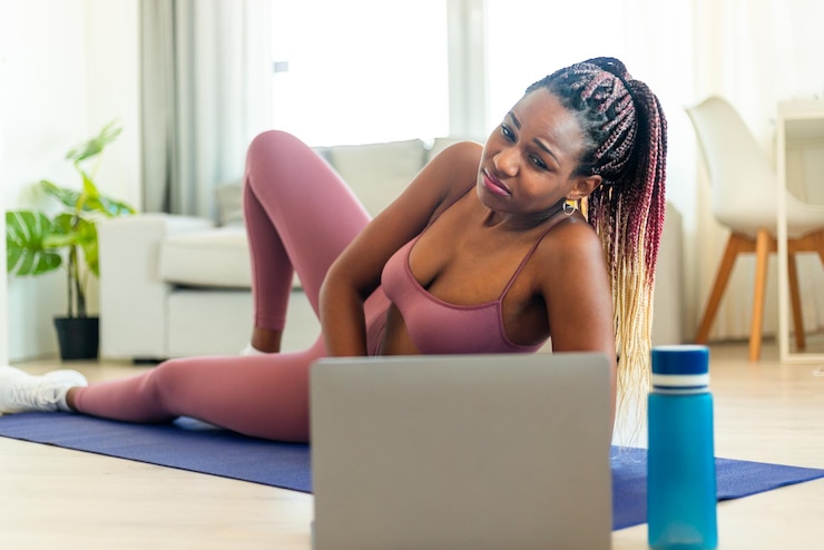 Photo fitness beginner exhausted black lady exercising with laptop tired after online workout lying on yoga mat