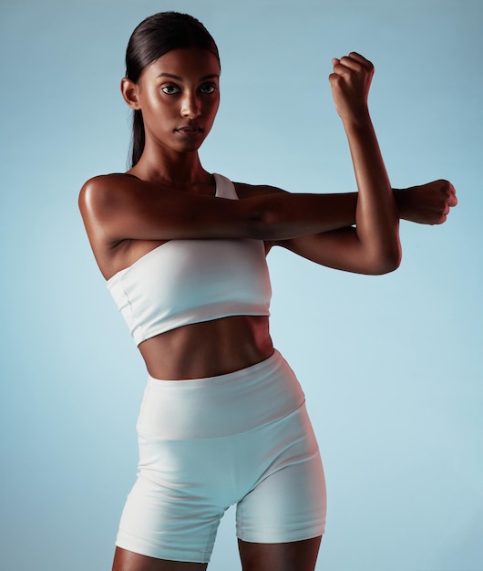 Фитнес-тело и растяжка чернокожей женщины в студии для тренировок или портрет оздоровительного образа жизни с макетом рекламы или маркетинга Молодая спортивная женщина с тренировочной модой на синем макете