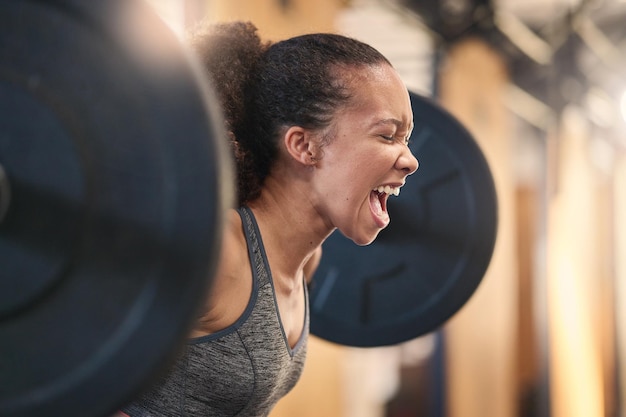 Photo fitness bodybuilder and shouting with a sports black woman weightlifting in a gym for a strong body exercise health and training with a female athlete shouting while lifting weights for a workout