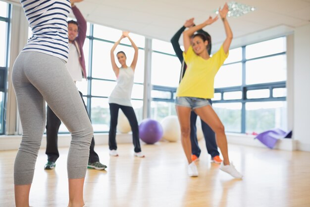 Fitness class and instructor doing pilates exercise