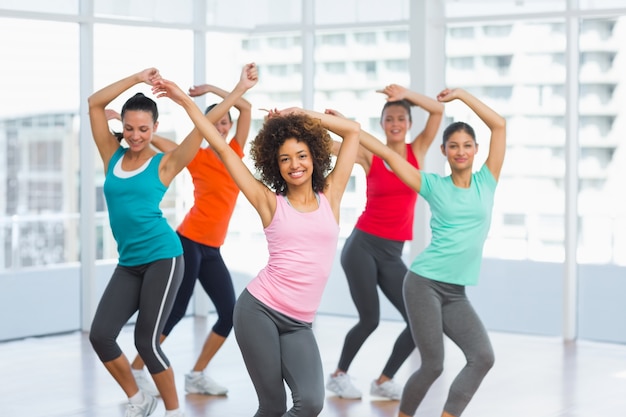 Photo fitness class and instructor doing pilates exercise