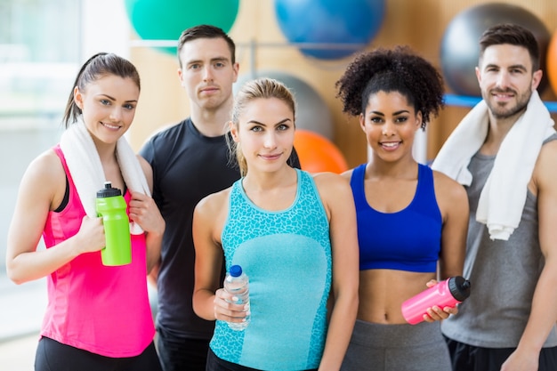 Fitness class smiling at camera in studio