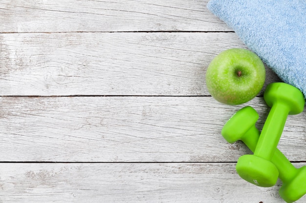 Fitness concept Dumbbells apple and towel