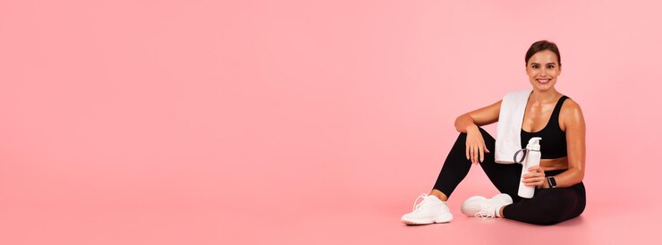 Photo fitness concept happy athletic lady sitting on the floor with water bottle