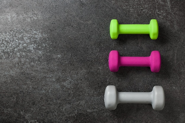 fitness concept with colorful dumbbells on black background