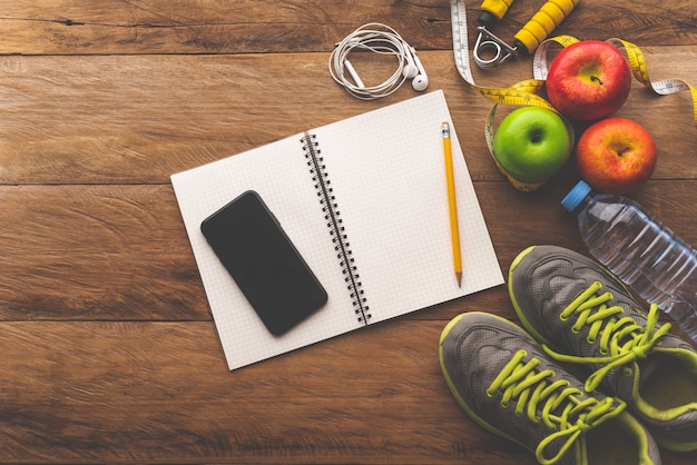 Fitness concept with Exercise Equipment on wooden table.