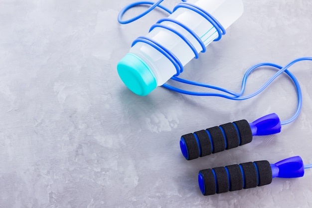 Fitness concept with jump rope and bottle of water
