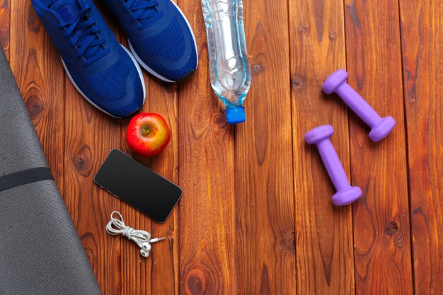 Fitness concept with sneakers, dumbbells