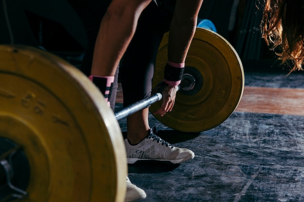 Fitness concept with woman touching barbell