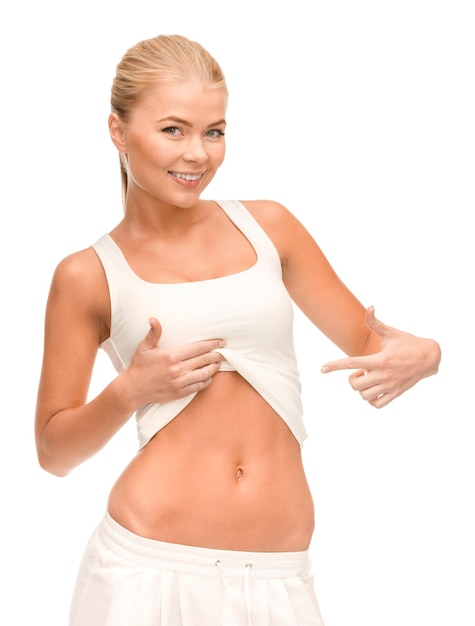 fitness and diet concept - beautiful sporty woman pointing at her abs