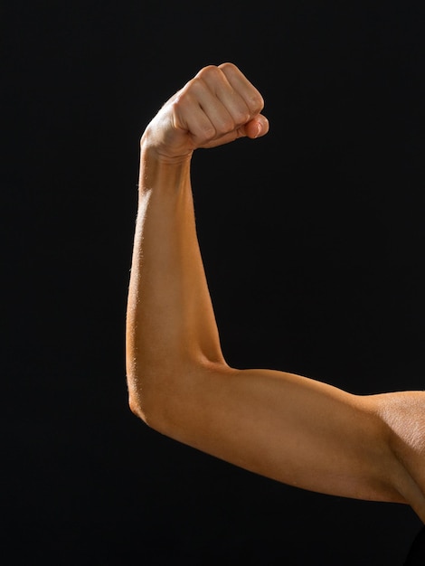 Foto concetto di fitness e dieta - primo piano di una donna atletica che flette i suoi bicipiti