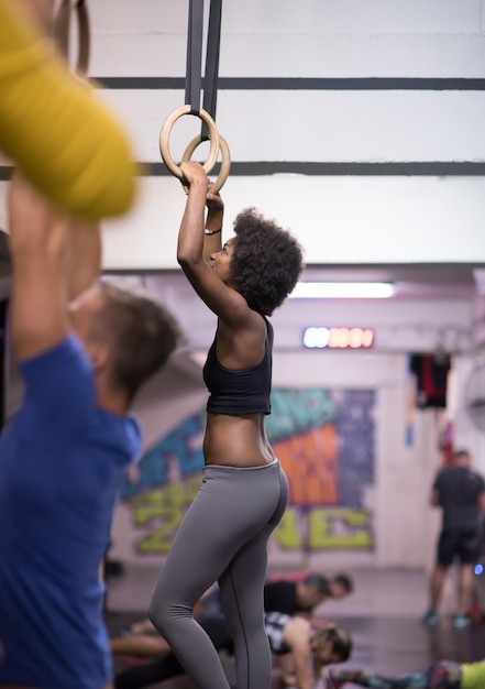 Photo fitness dip ring beautiful young african american woman workout at gym dipping exercise