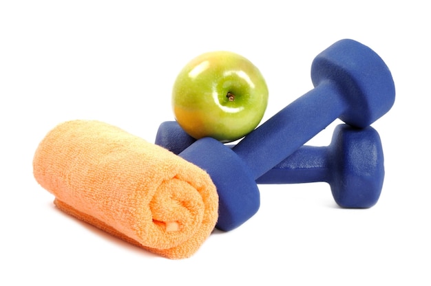 Fitness dumbbells towel and fruits  over white