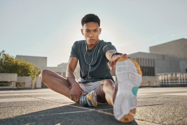 Premium Photo Fitness earphones and man stretching hamstring in