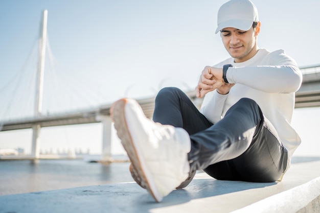 Fitness elektronisch horloge bij de hand lopende mannelijke atleet voert fitnesstraining uit