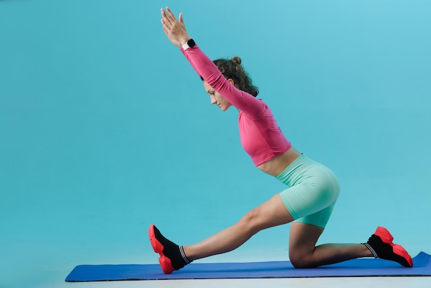 Fitness- en dieetconcept Jonge vrouw met atletisch lichaam en perfecte billen ligt op haar rug en doet oefeningen