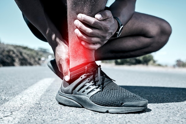 Fitness enkel en blessure met een sportman die zijn gewricht pijn houdt terwijl hij buiten is voor een training Oefen noodgevallen en ongelukken met een mannelijke atleet die zich zacht voelt tijdens het trainen voor recreatie