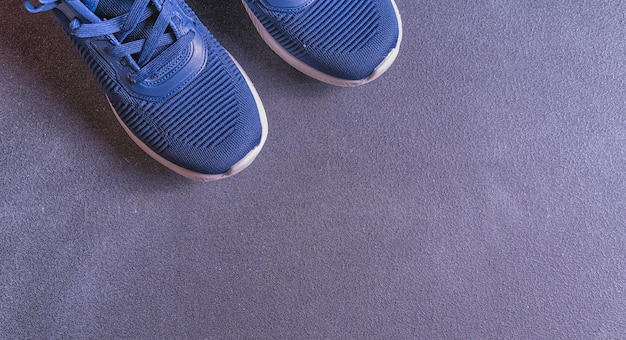 Fitness equipment with sneakers on gray background